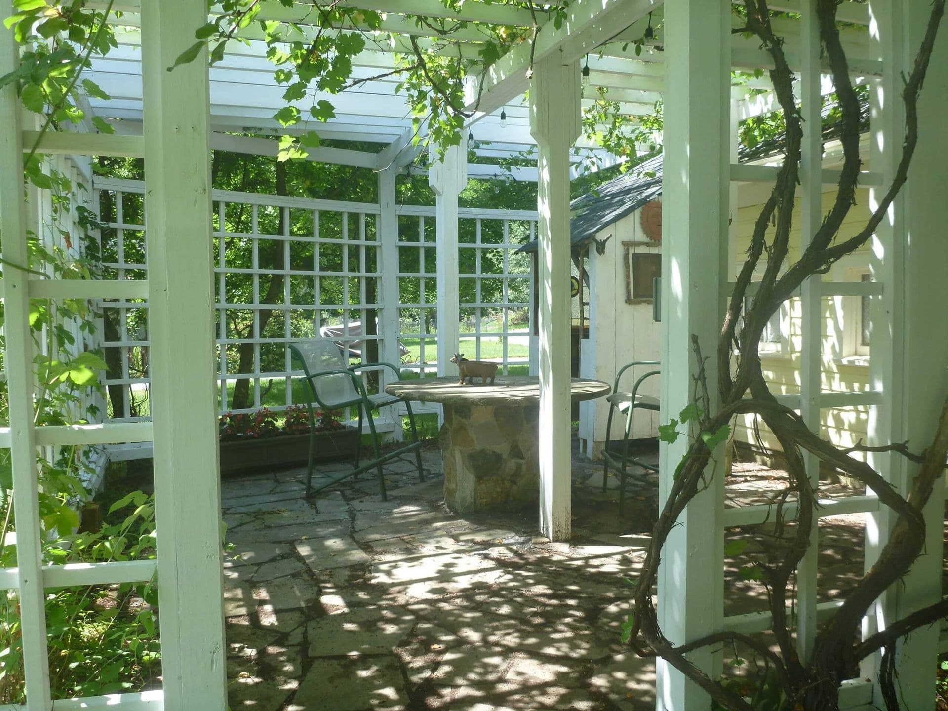 A serene outdoor seating area framed by white lattice and greenery.